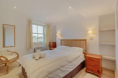 a bedroom with a large bed and a chair at 2 Bed in Polruan oc-g30534 in Fowey