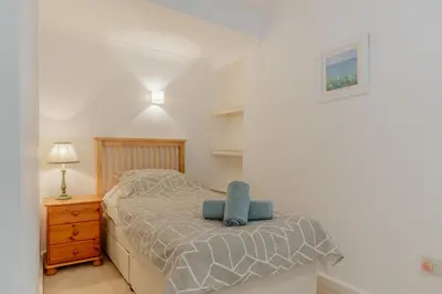 a bedroom with a bed with a blue chair on it at 2 Bed in Polruan oc-g30534 in Fowey
