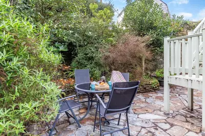 a patio with a table and chairs on a stone patio at 2 Bed in Polruan oc-g30534 in Fowey