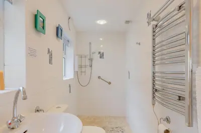 a white bathroom with a shower and a sink at 2 Bed in Polruan oc-g30534 in Fowey