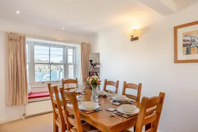 a dining room with a table and chairs and a window at 3 Bed in Polruan oc-g30535 in Fowey