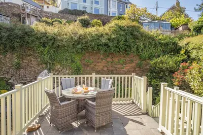 a patio with a table and chairs on a fence at 3 Bed in Polruan oc-g30535 in Fowey