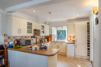 a kitchen with white cabinets and a wooden counter top at 3 Bed in Polruan oc-g30535 in Fowey