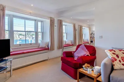 a living room with a red chair and a window at 3 Bed in Polruan oc-g30535 in Fowey