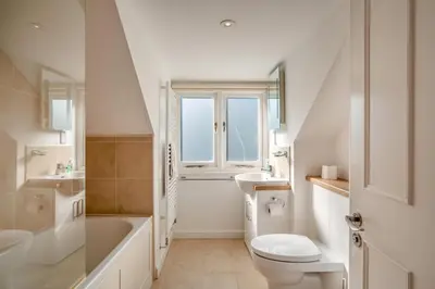 a white bathroom with a sink and a toilet at 3 Bed in Polruan oc-g30535 in Fowey