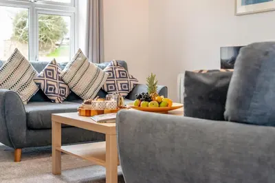 a living room with a couch and a table with fruit on it at 4 Bed in Newquay oc-c30589 in Saint Columb Major