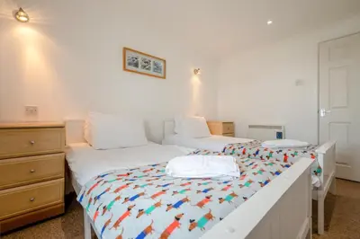 a bedroom with two beds and a dresser at 4 Bed in Newquay oc-c30589 in Saint Columb Major