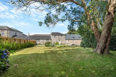 a large yard with a house and a tree at 2 Bed in St. Gluvias oc-c29724 in Ponsanooth