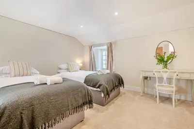 a bedroom with two beds and a desk and a mirror at 2 Bed in St. Gluvias oc-c29724 in Ponsanooth