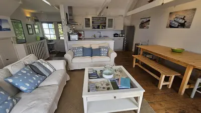 a living room with a couch and a table at Workshop in Saint Mawes