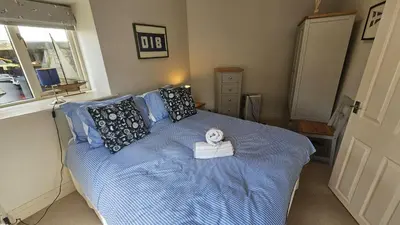 a bedroom with a bed with a alarm clock on it at Workshop in Saint Mawes