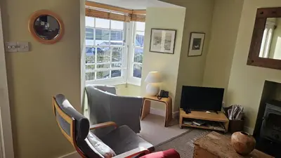 a living room with two chairs and a television at Charlies in Saint Mawes