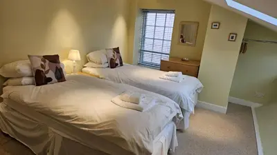 a bedroom with two beds and a window at Charlies in Saint Mawes