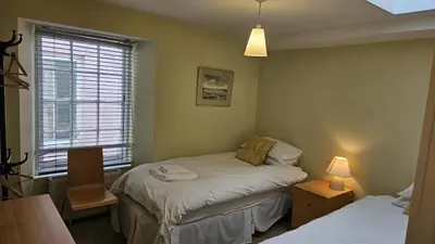 a small room with two beds and a window at Charlies in Saint Mawes