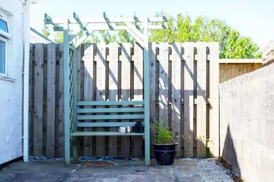 a fence with a gate with a stairway and a wooden gate at The Sty, rural retreat for couples in Falmouth