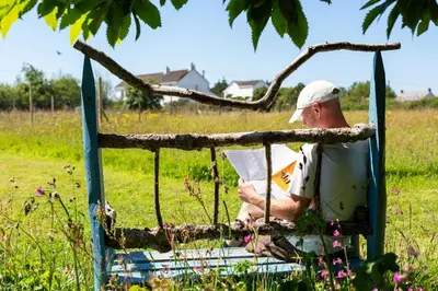 a man sitting in a chair under a tree at The Sty, rural retreat for couples in Falmouth