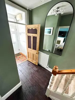 a room with a mirror and a staircase with a door at Skylark House Padstow, Stylish Victorian Townhouse, Private Sauna, Cold Plunge and Log Burner in Padstow