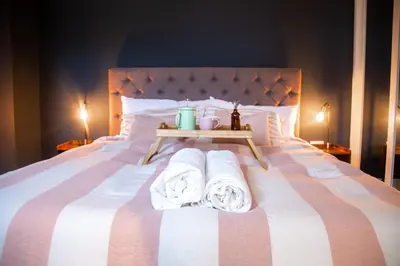 a bedroom with a bed with towels on it at Skylark House Padstow, Stylish Victorian Townhouse, Private Sauna, Cold Plunge and Log Burner in Padstow