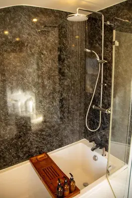 a bathroom with a shower and a bath tub at Skylark House Padstow, Stylish Victorian Townhouse, Private Sauna, Cold Plunge and Log Burner in Padstow