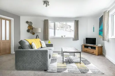 a living room with a couch and a table at Life of Riley in St Ives