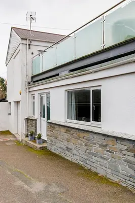 a white building with a window on the side of it at Life of Riley in St Ives