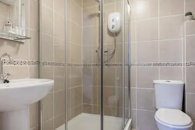 a bathroom with a shower and a toilet and a sink at Life of Riley in St Ives