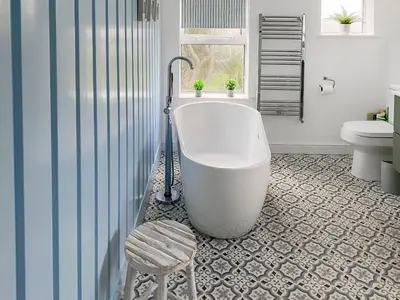 a bathroom with a tub and a toilet and a stool at Greycott - Uk48746 in Crantock