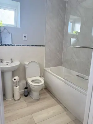 a bathroom with a toilet and a tub and a sink at Sea Spire Coach House in Charlestown