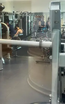 a gym with machines and people in the background at Peaceful room near to beach - Newquay Porth in Saint Columb Minor