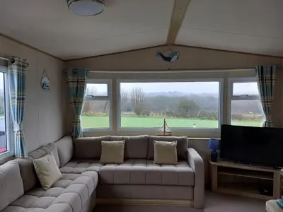 a living room with a couch and a flat screen tv at Gateway to Cornwall in St Austell