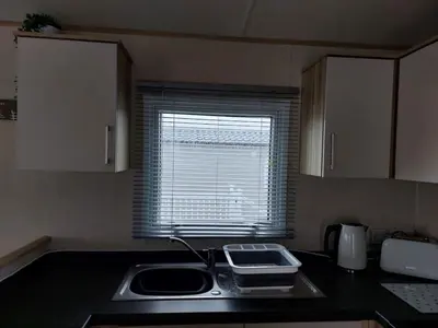 a small kitchen with a sink and a window at Gateway to Cornwall in St Austell