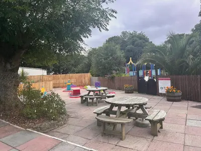 a patio with picnic tables and a playground at Trevithick 46 in Hayle