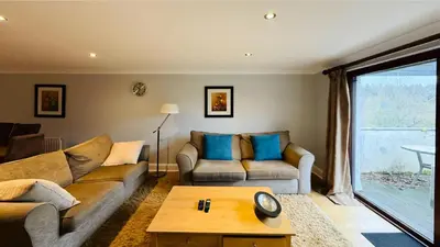 a living room with a couch and a table at Hustyn Lodges in Saint Wenn