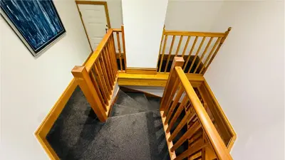 a stairway with a wooden bench in a room at Hustyn Lodges in Saint Wenn