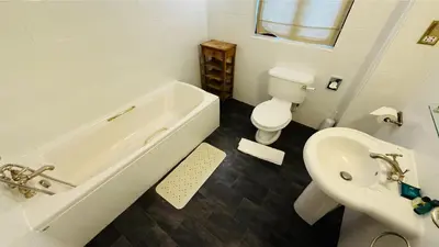 a bathroom with a tub and a toilet and a sink at Hustyn Lodges in Saint Wenn