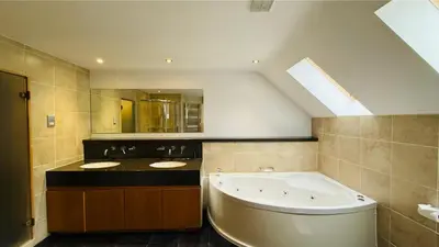 a bathroom with a large tub and a sink at Hustyn Lodges in Saint Wenn