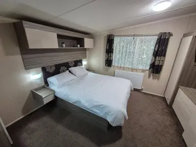 a small bedroom with a white bed and a window at Swift in Saint Columb Road Station