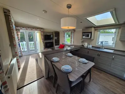 a kitchen with a wooden table and a dining room at Swift in Saint Columb Road Station