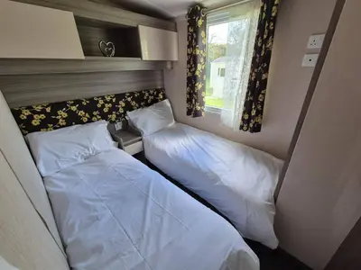 a small bedroom with two beds and a window at Swift in Saint Columb Road Station