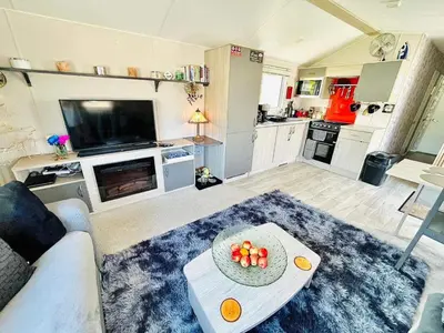 a living room with a couch and a table with fruit on it at Newquay Seaside Lodge Retreat with Hot Tub in Newquay