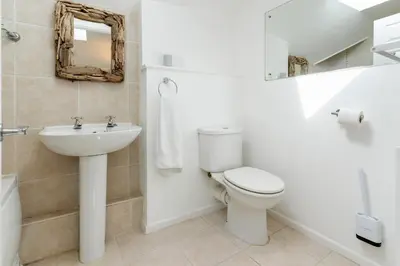 a bathroom with a toilet and a sink and a mirror at The White House in Wadebridge