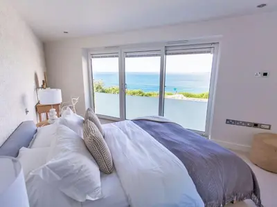 a bedroom with a bed with a view of the ocean at 7 Atlantic Watch in St Ives