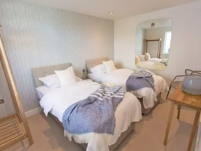 a bedroom with two beds and a mirror at 7 Atlantic Watch in St Ives