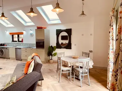 a living room with a couch and a table at Bream Loft, dog friendly, wood burner, walking distance to beach in Falmouth