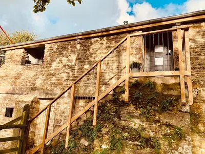 a stairway leading up to a window on a brick building at Bream Loft, dog friendly, wood burner, walking distance to beach in Falmouth
