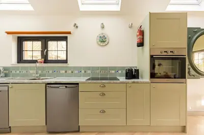 a kitchen with a sink and a dishwasher at Bream Loft, dog friendly, wood burner, walking distance to beach in Falmouth