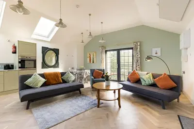 a living room with two couches and a table at Bream Loft, dog friendly, wood burner, walking distance to beach in Falmouth