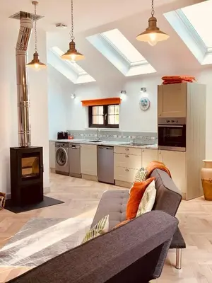 a living room with a couch and a kitchen at Bream Loft, dog friendly, wood burner, walking distance to beach in Falmouth