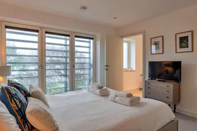a bedroom with a large white bed and a television at Finest Retreats - Tamsin in Newquay