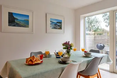 a dining room with a table with a plate of food at Finest Retreats - Tamsin in Newquay